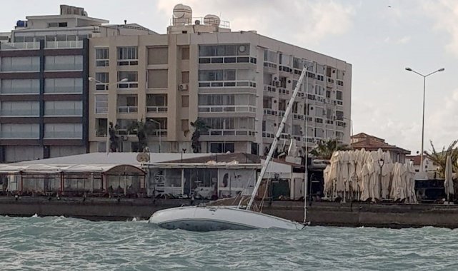Çeşme'de fırtına nedeniyle yan yatan tekne karaya vurdu