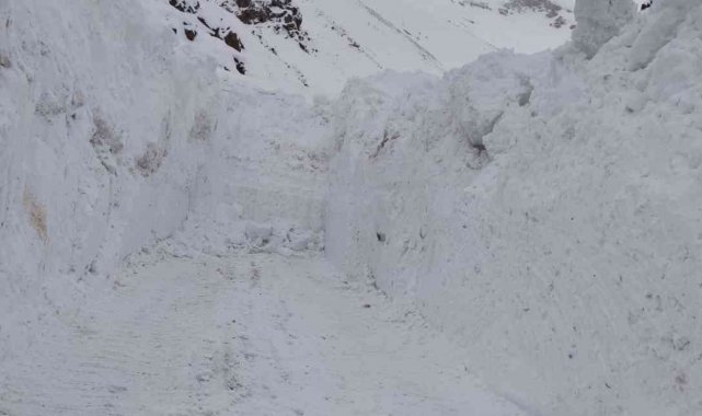 Kar kalınlığının iş makinelerinin boyunu geçtiği yolda zorlu çalışma
