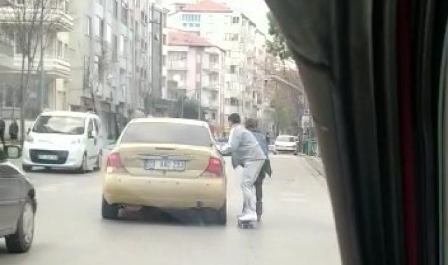 Otomobile tutunan kaykaylı genç az daha canından oluyordu