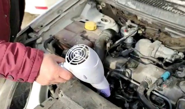 Saç kurutma makinesiyle donan aracını ısıttı