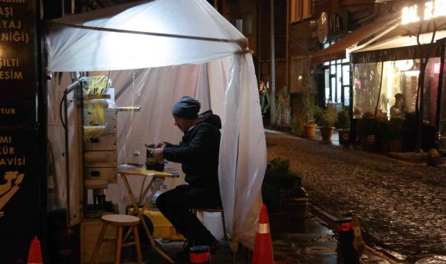 Soğuktan korunmak için sokakta kurduğu çadırda çalışıyor