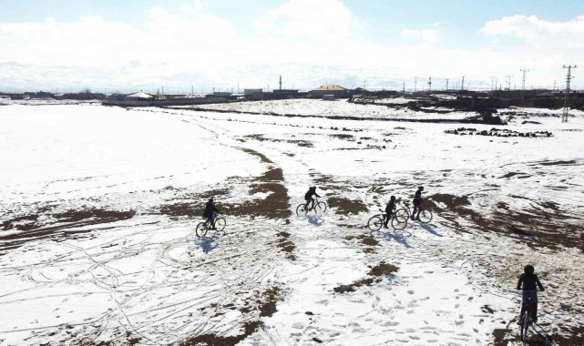 Çocuklar kar üzerinde bisiklet sürüp balon uçurdular