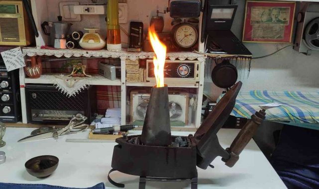 Terzi kömürlü ütüyle kumaşları ütülüyor