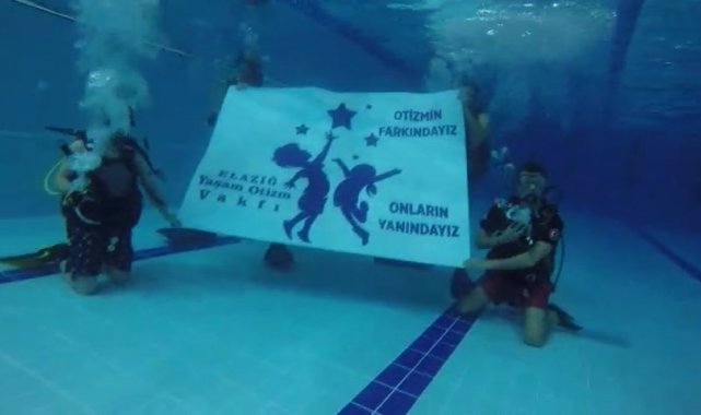 Su altında "Otizmin farkındayız, onların yanındayız" pankartı