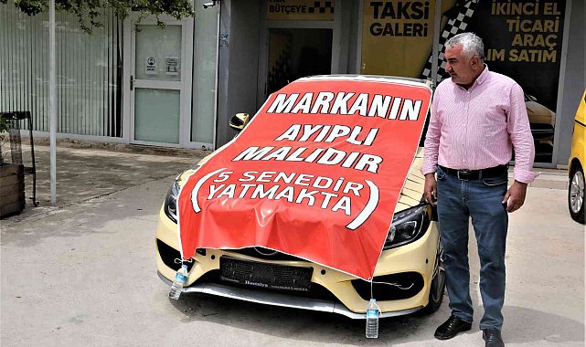 Aldığı lüks aracı işyerinin önüne koyup, üzerine "Markanın ayıplı malıdır, 5 yıldır yatmakta" yazdı