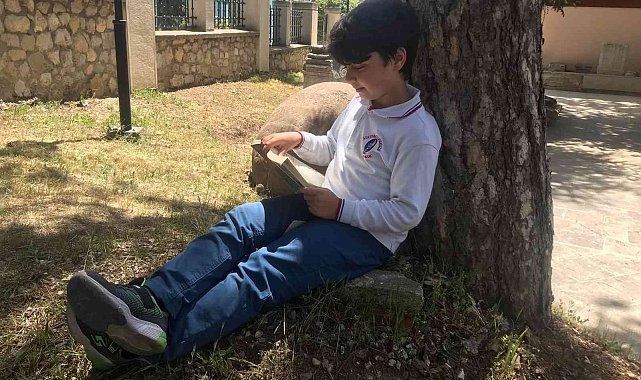 Çocuklar müze bahçesinde kitap okumak için bir araya geldiler