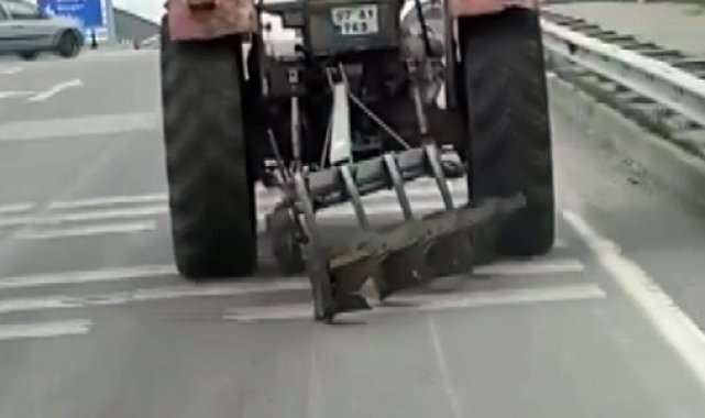 Traktör arkasındaki sabanla asfaltı çizerek karayolunda seyir etti